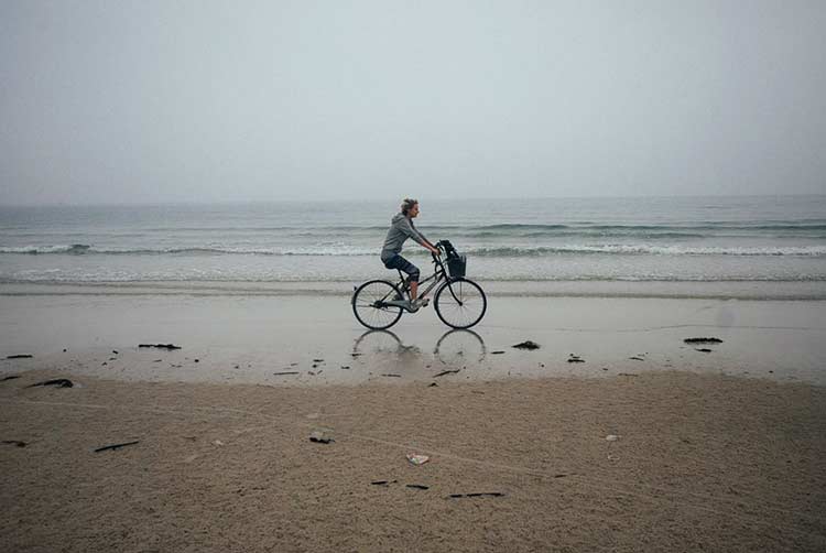 Девушка на велосипеде по пляжу